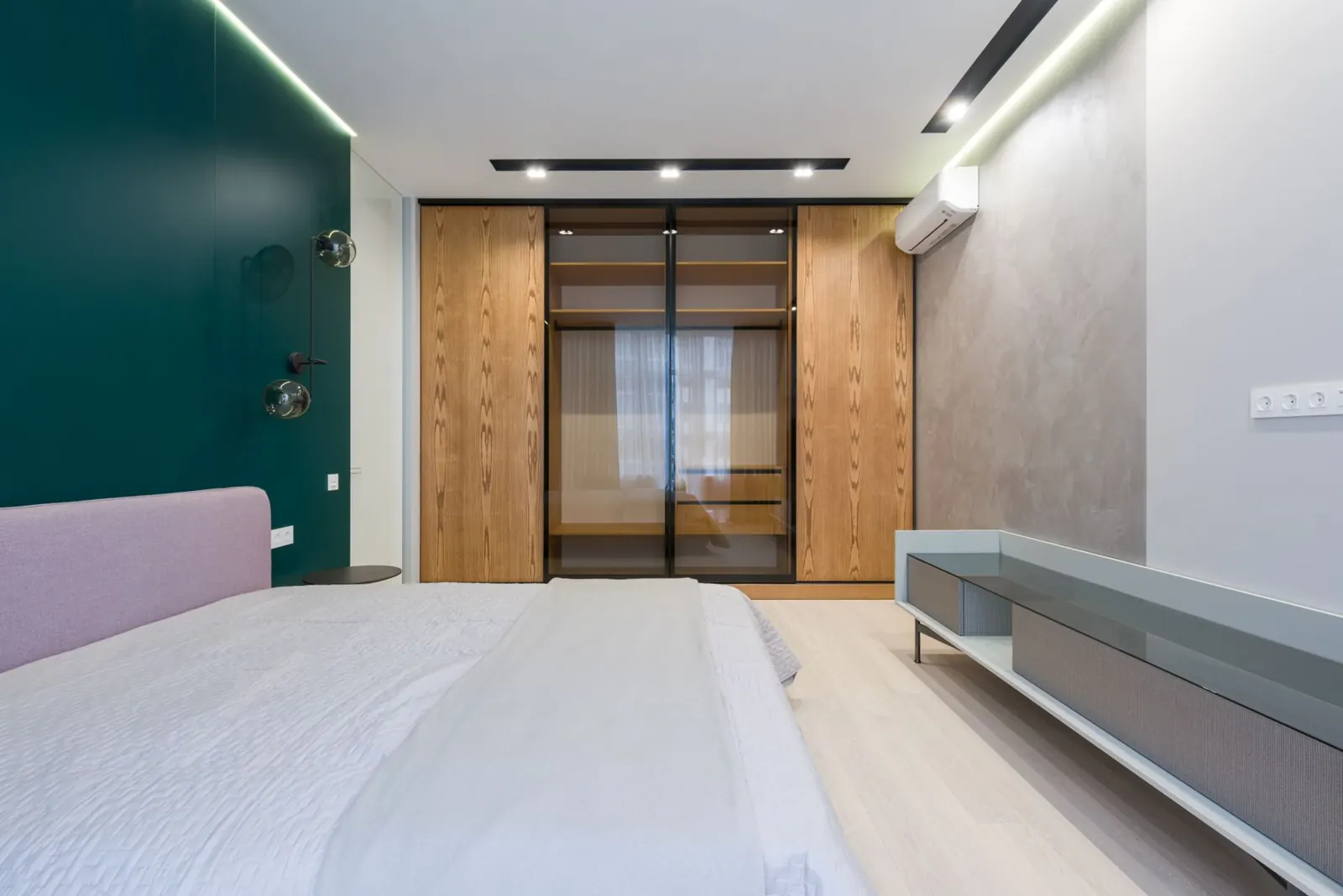 A bedroom with a wall-mounted air conditioning unit