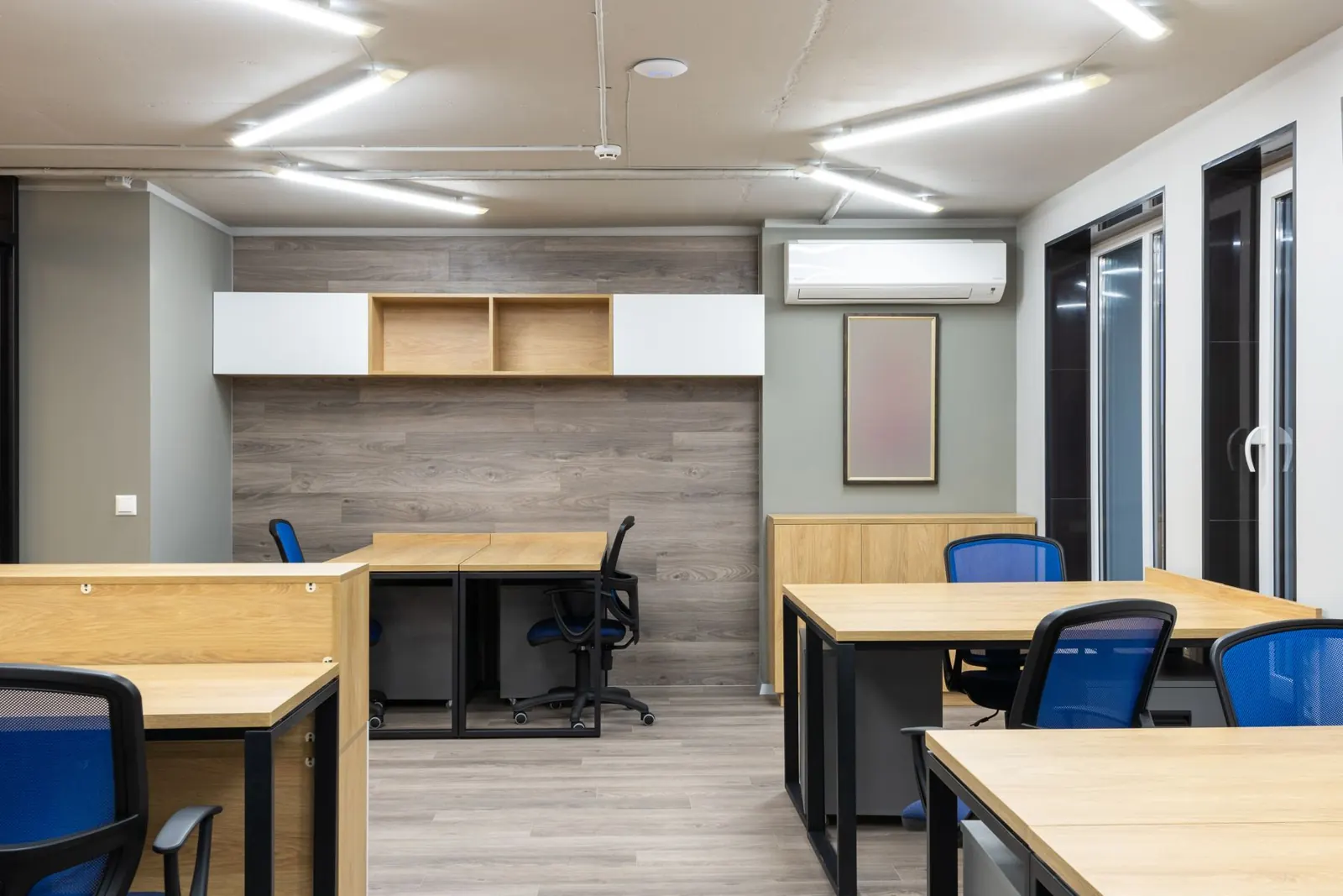 A room with desks and a wall-mounted air conditioning unit